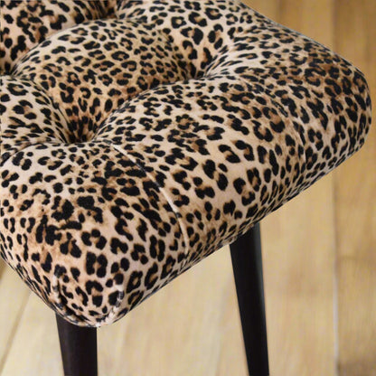 Top-down view of the Leopard Print Curve Stool's seat, showcasing the vibrant leopard print and classic deep button style.