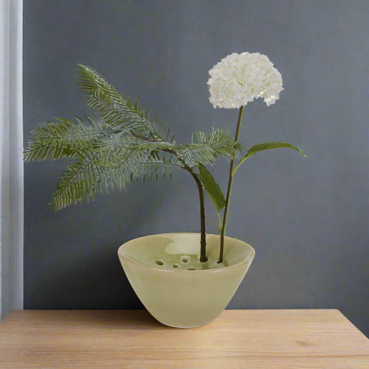 Elevated front view of the flower frog vase holding two stems.