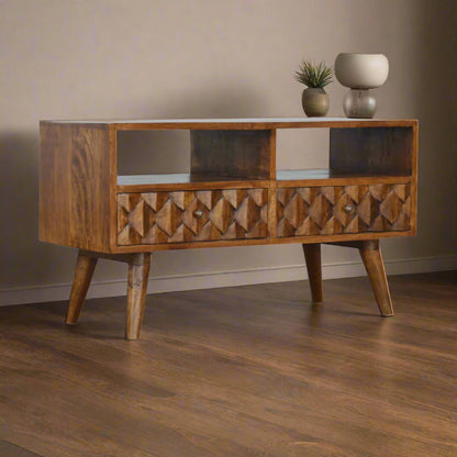 Angled view of mango wood TV stand with pineapple pattern drawer fronts and open shelf storage