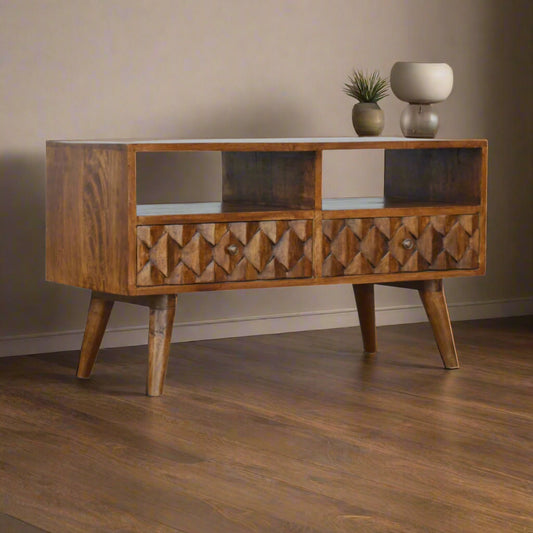 Angled view of mango wood TV stand with pineapple pattern drawer fronts and open shelf storage