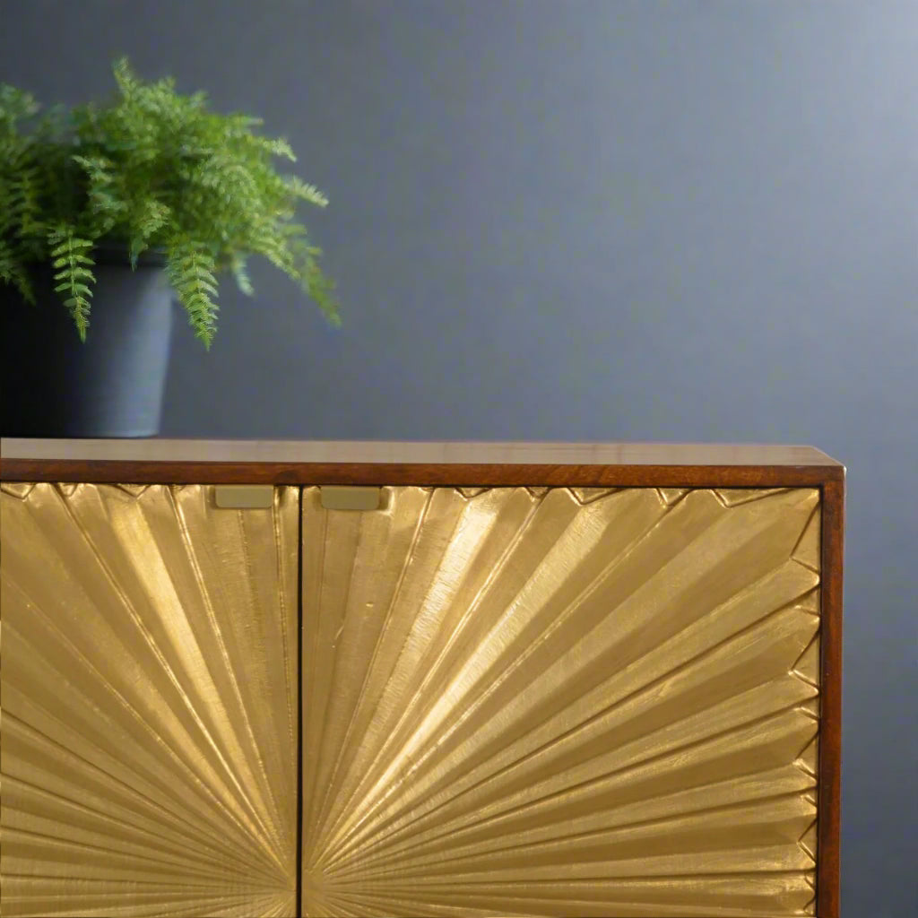 Close-up detail of the brass-plated sunburst design on the door of the Manila Gold Cupboard, showing the craftsmanship and the rich chestnut finish.