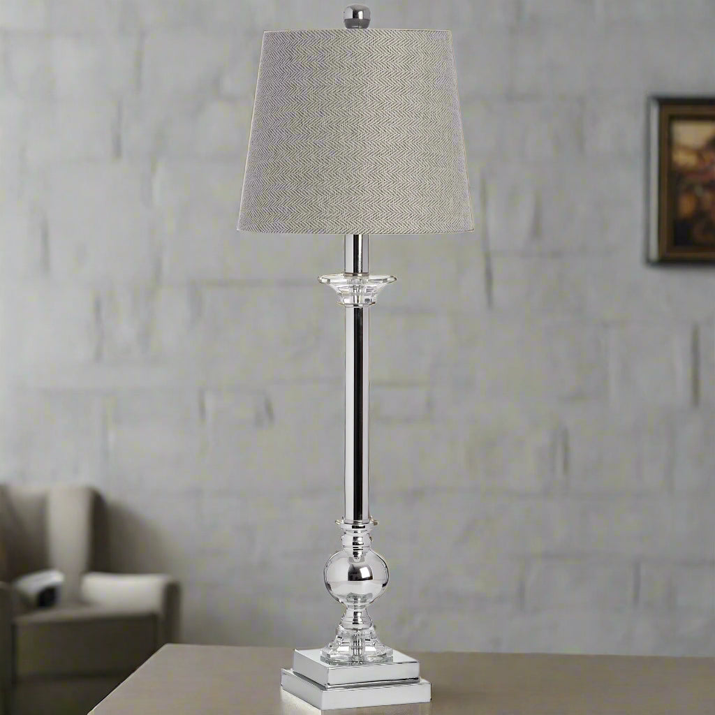 Full view of the Milan Chrome Table Lamp with a tall grey and white herringbone shade and reflective chrome base, styled in a modern room setting.