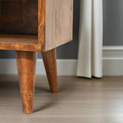 Mini Manila bedside table with gold sunburst drawer, chestnut finish, Nordic legs, and open slot. Elegant handcrafted bedroom storage.