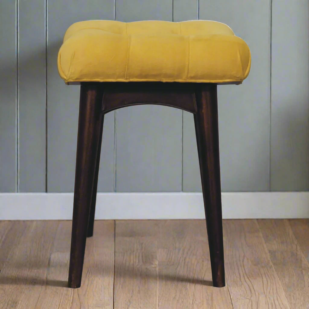 Full side view of the mini mustard velvet curve stool, displaying its curved shape and overall compact design.