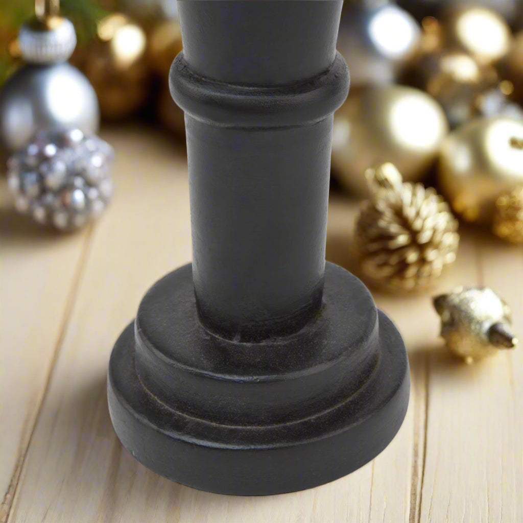 Close-up of the sturdy base of a minimalist black wooden nutcracker decoration, emphasizing its clean lines and stable design.
