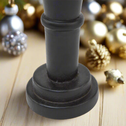 Close-up of the sturdy base of a minimalist black wooden nutcracker decoration, emphasizing its clean lines and stable design.