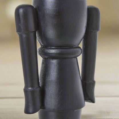 Detailed view of the middle section of a minimalist black wooden nutcracker decoration, highlighting the smooth solid wood construction.