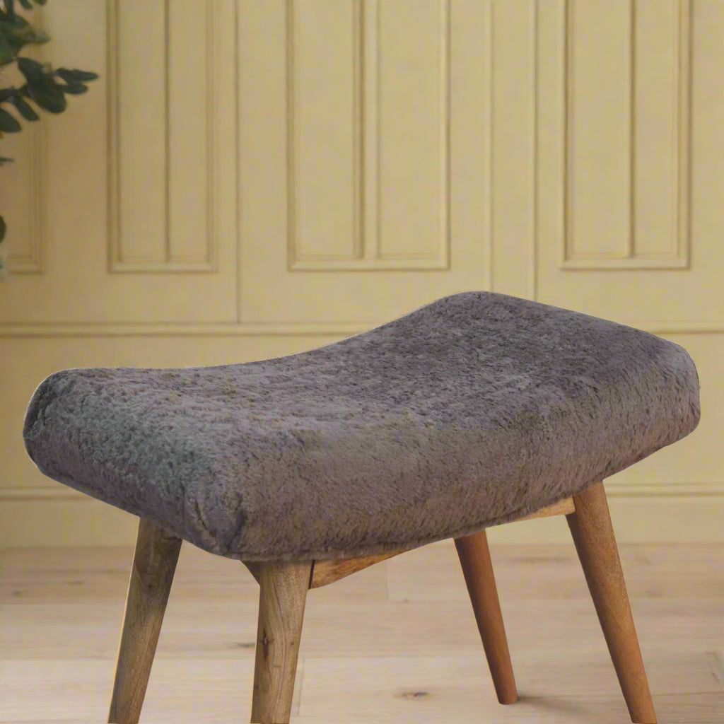 Elevated angled view of the Mocha Faux Fur Curve Stool, showing its comfortable seat and a section of its sturdy Nordic style legs.