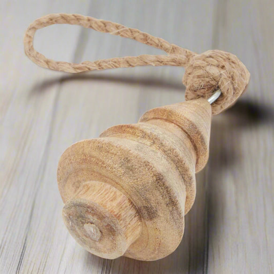Close-up of a natural hand-turned wooden tree bauble, highlighting the craftsmanship, smooth finish, and sturdy knotted rope hanger.