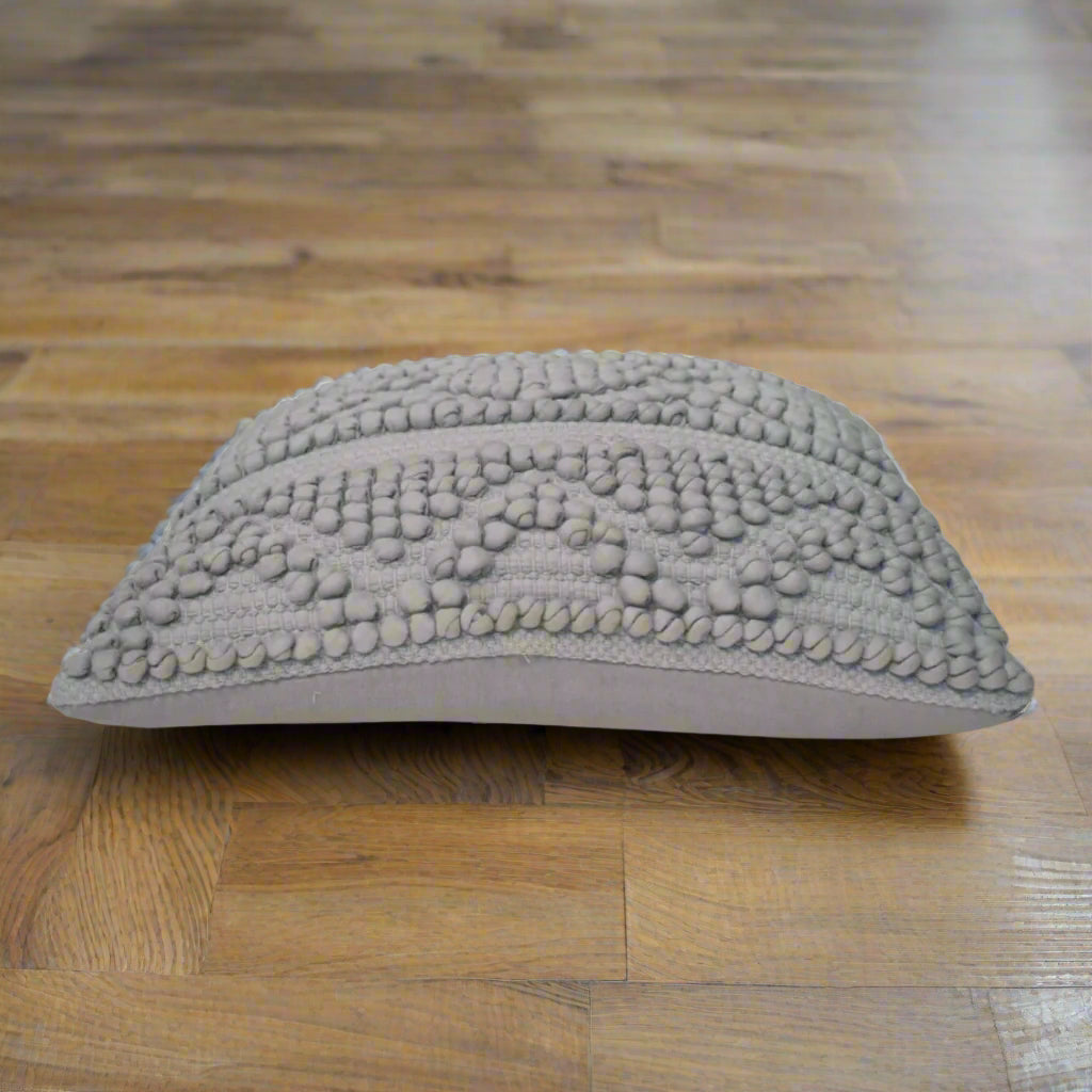 Side view of grey woven Nola cushion with plump profile placed on a modern floor – Purple Flamingo UK
