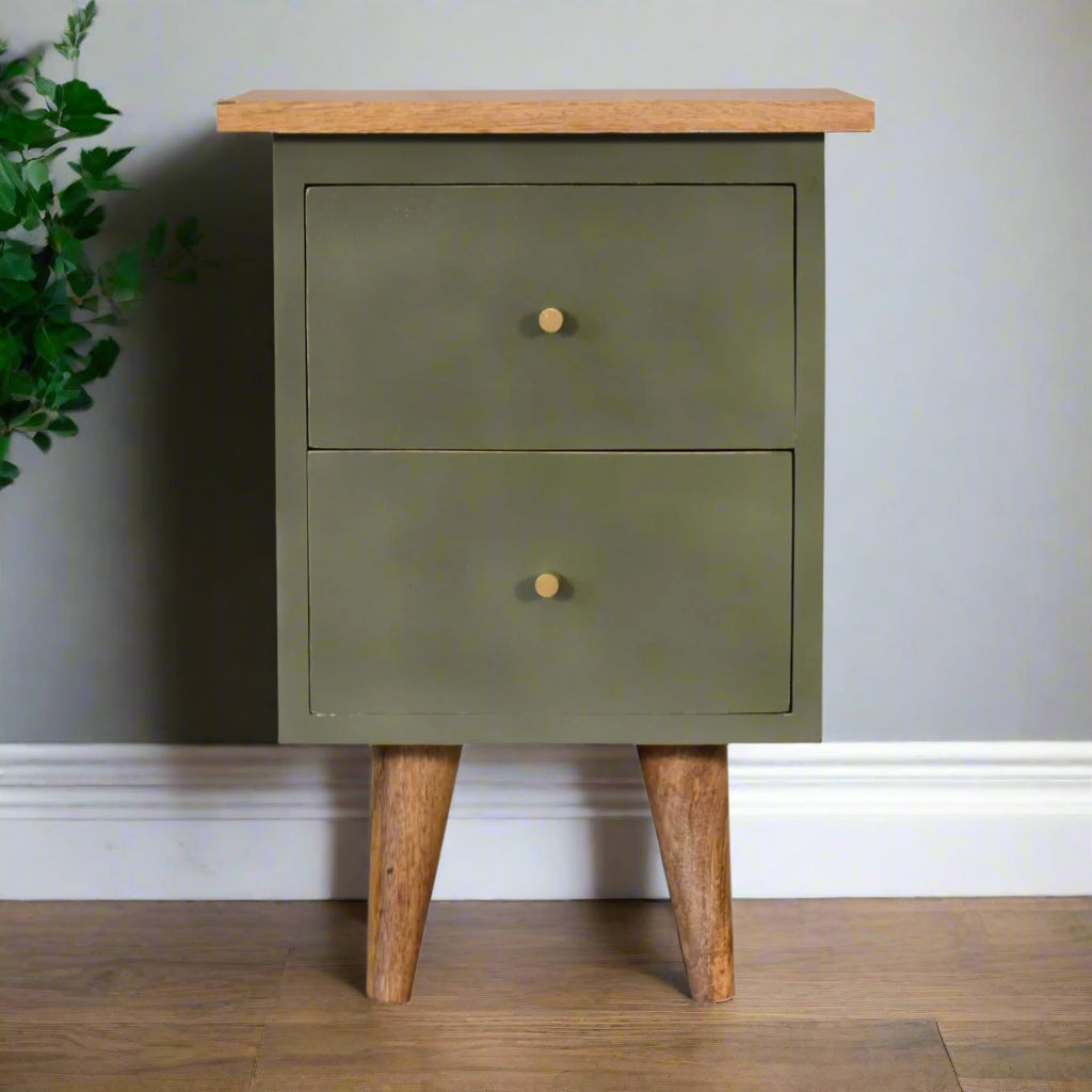 Front view of the olive hand-painted bedside table, showcasing its front, Nordic style legs, and an ornamental inhouse plant on the side.