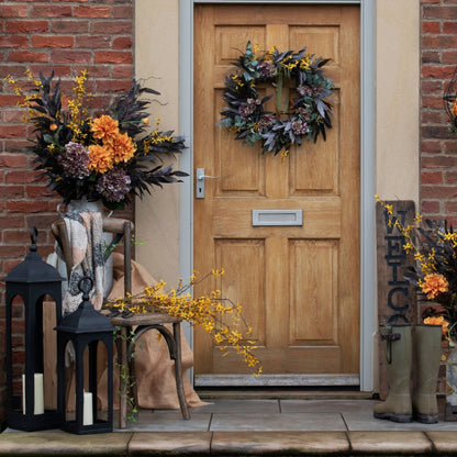 Orange dahlia spray used in a cozy porch display for fall entryway styling.