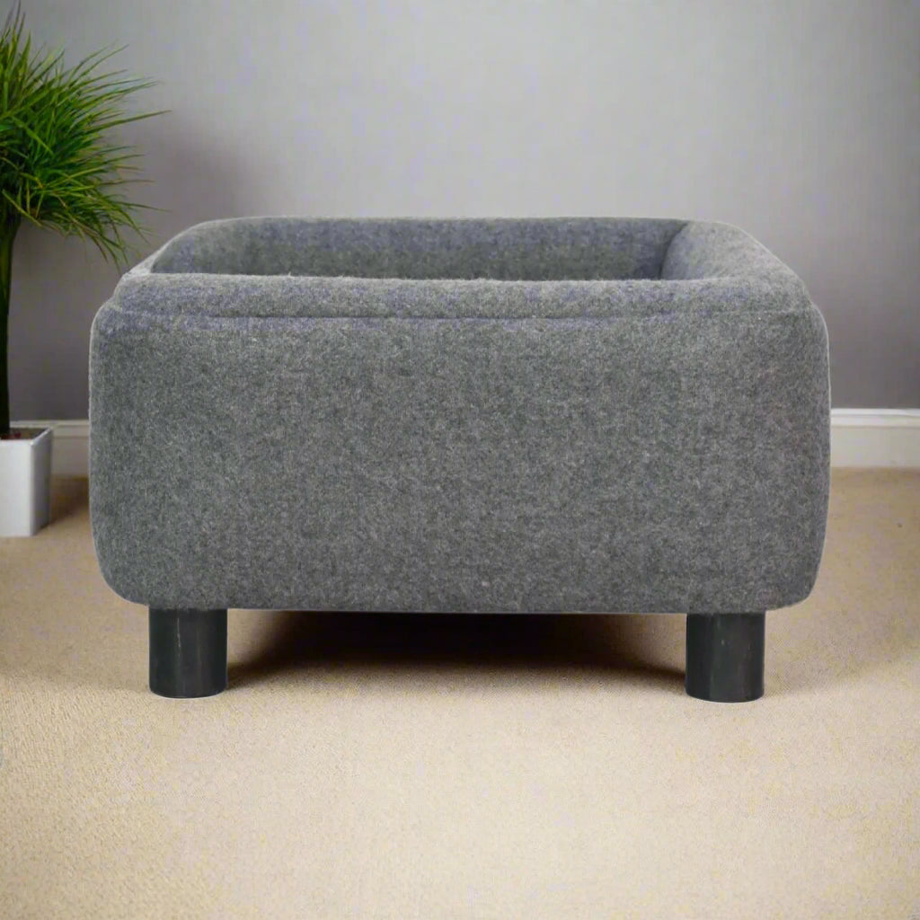 Full side view of the pet sofa bed in a decorated room with plant backdrop.