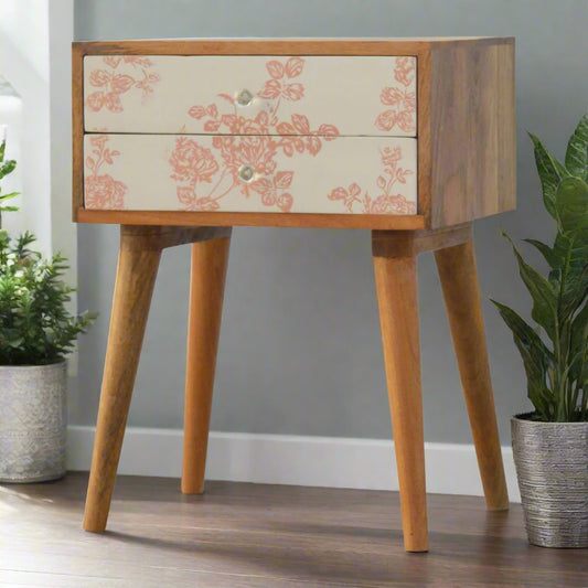Angled view of bedside table with pink floral screen-printed drawers and four Nordic-style legs in oak-ish finish – Purple Flamingo UK