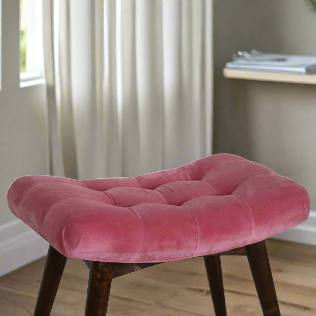Elevated view of the Pink Velvet Curve Stool's seat, showing the plush upholstery and a fraction of the top part of its legs.