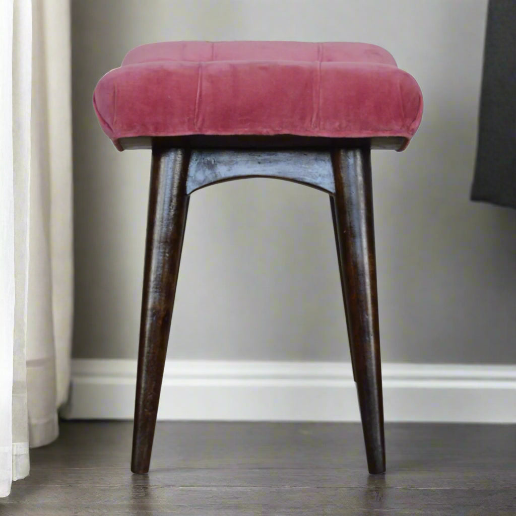 Side profile view of the Pink Velvet Curve Stool, showcasing its curved design and Nordic legs from the side.