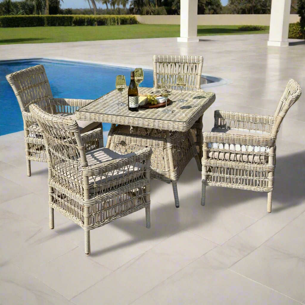 Full view of the Provence 4-Seater Dining Set in an inviting outdoor garden setting, featuring a glass-top table and four chairs.