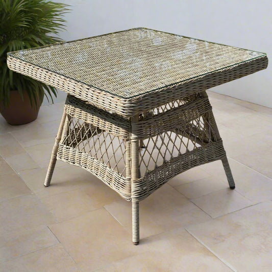 Close-up of the Provence 4-Seater Dining Set table, highlighting its wicker weave, tempered glass top, and comfortable chairs.
