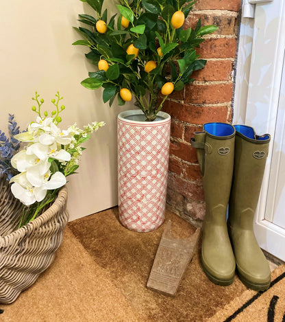 Purple Flamingo red and white daisy chain ceramic umbrella stand with a lemon tree plant, styled in a hallway entrance with wellington boots.