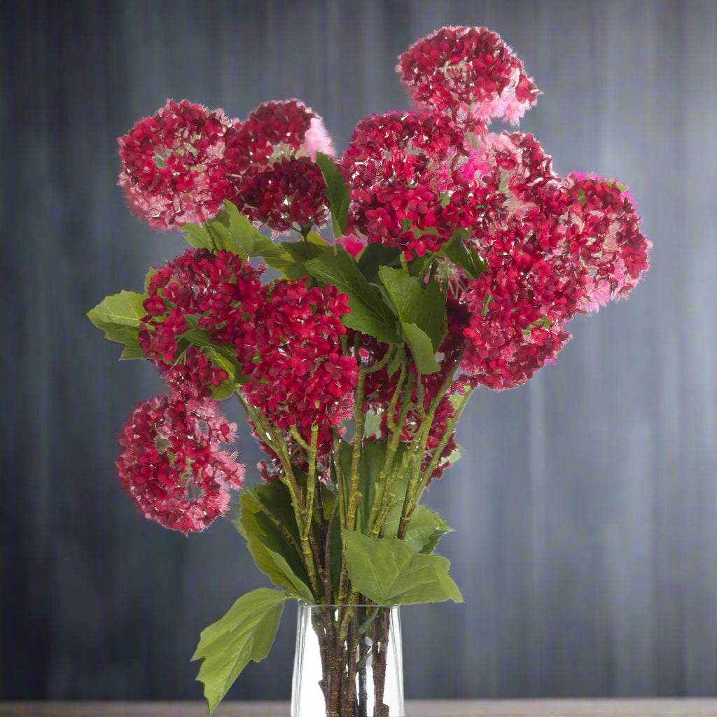Front view of red viburnum stems in a clear vase.