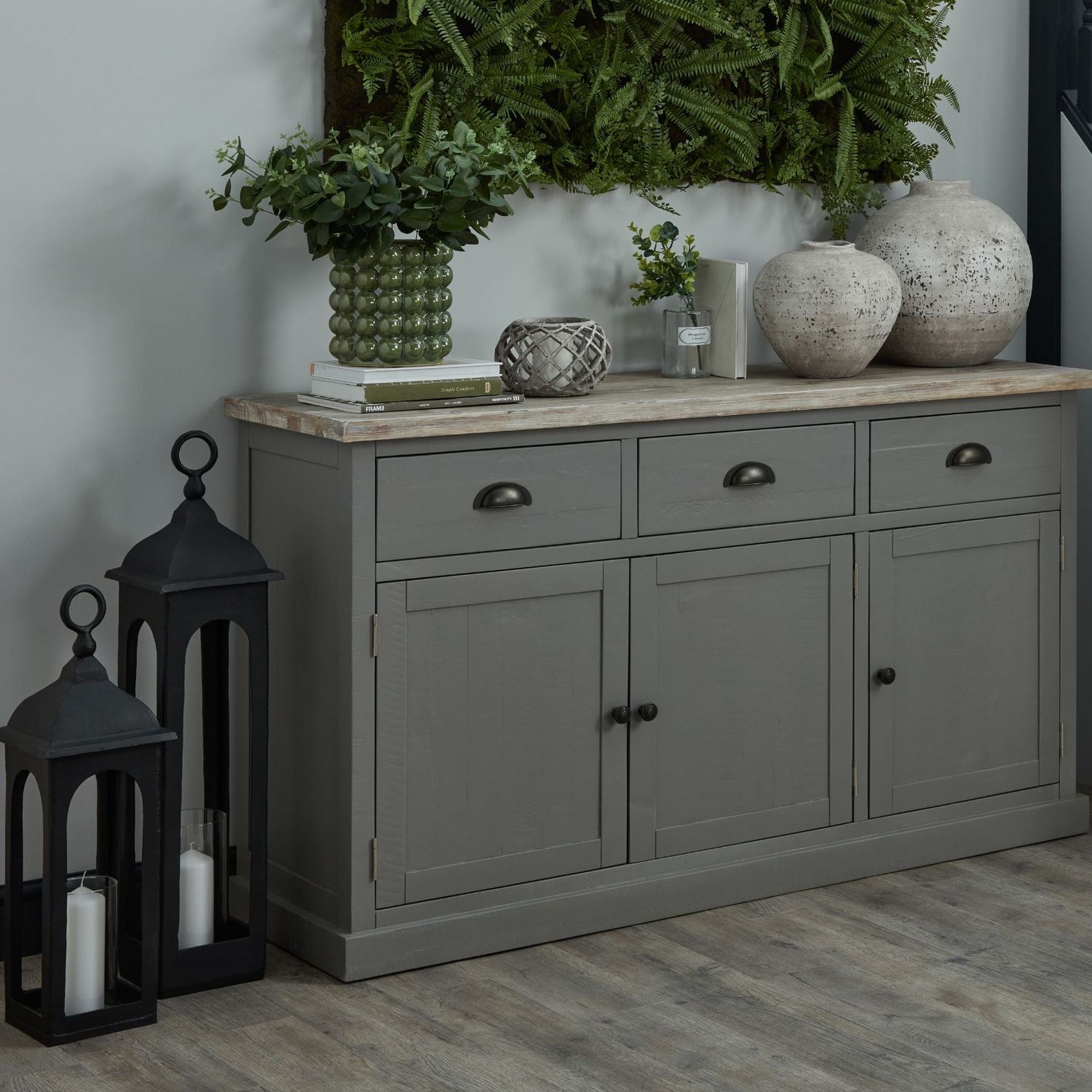 Angled shot of the lantern on a grey cupboard with floral décor and a white top.