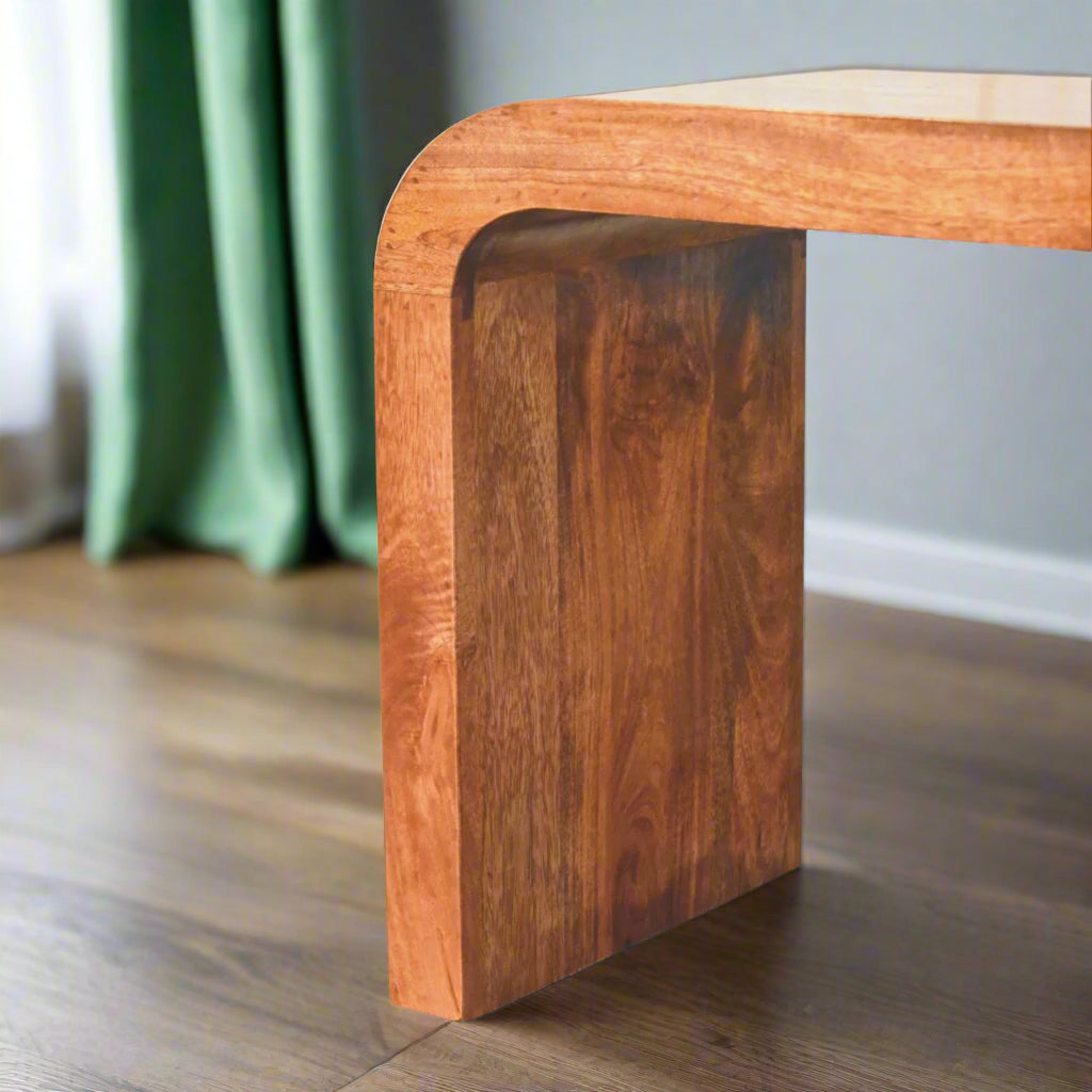 Close-up focus on the curved edge of the Serenity Coffee Table, highlighting the smooth transition of the design.