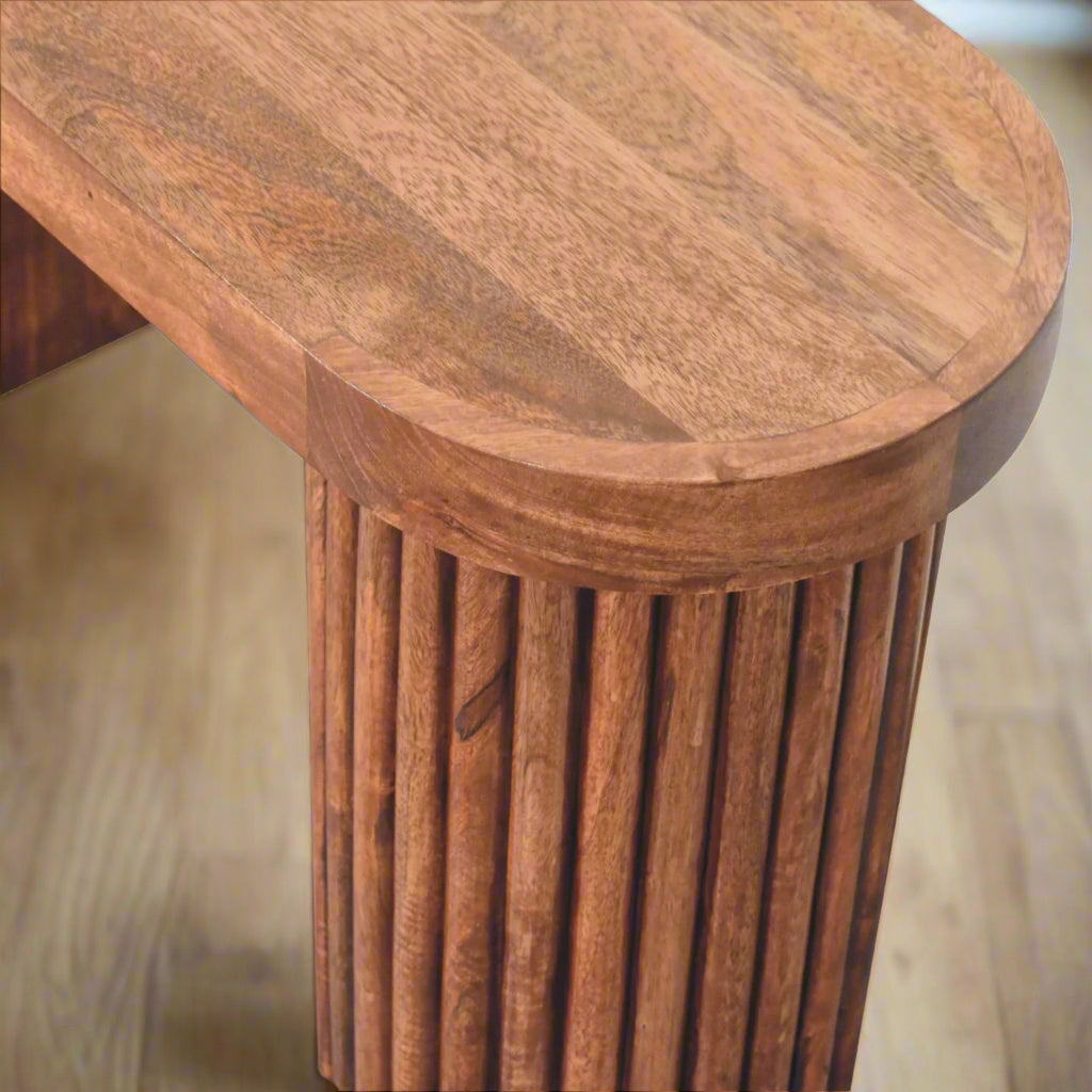 Top-down view of the Serenity Coffee Table, showing one of its cylindrical stands and the rich wooden texture of the honey caramel finish.