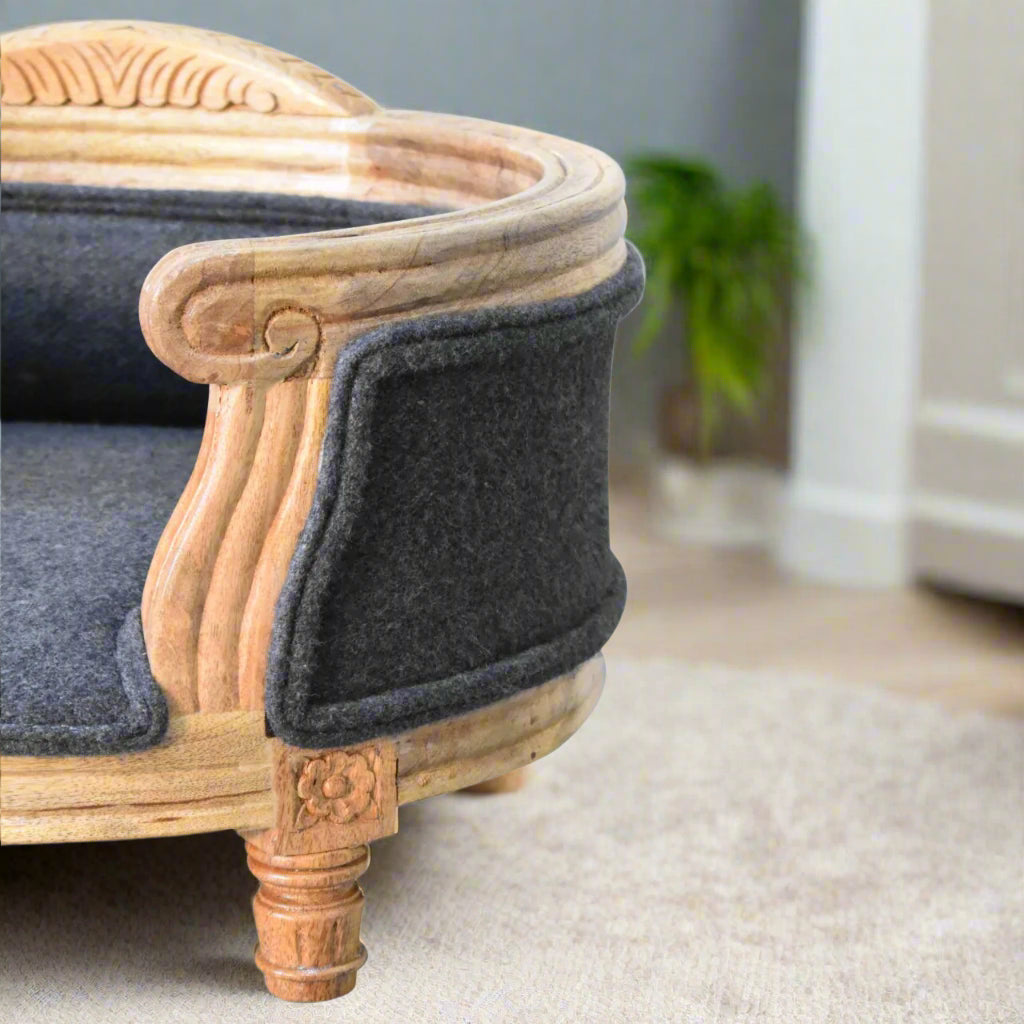  Side angle of the carved wooden pet bed, emphasizing the scroll arm detail and rich tweed upholstery.