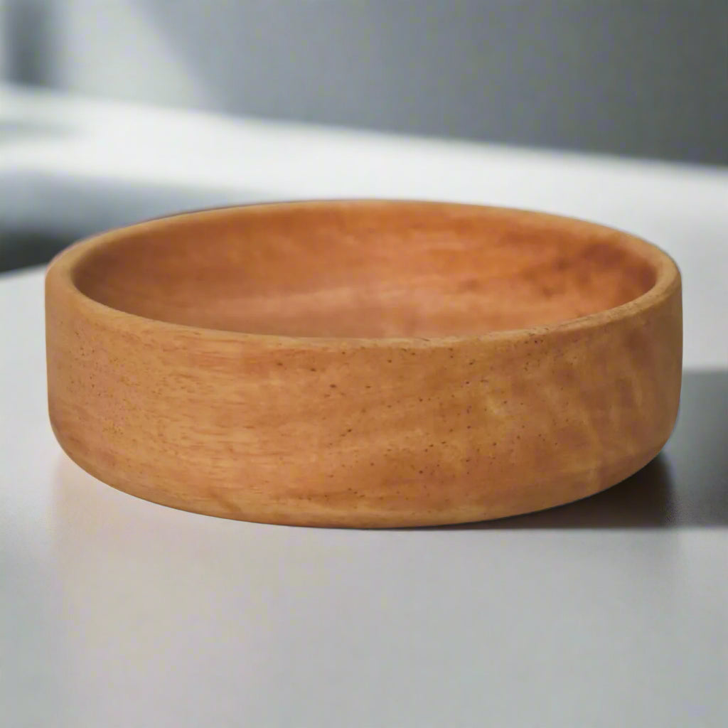 Angled view of single mango wood bowl showing inner and outer surfaces.