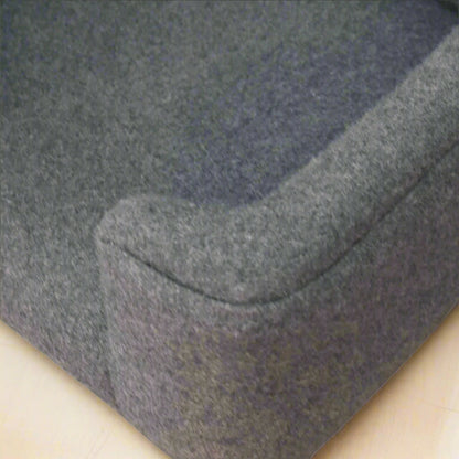Top-down closeup of the curved left front side of the pet bed showing stitching.