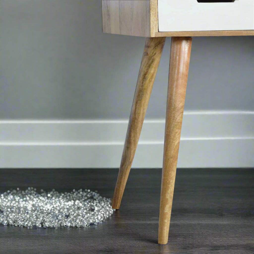 Detail view of Nordic style tapered mango wood legs on standard straight edge pink gradient dressing table with decorative accessories