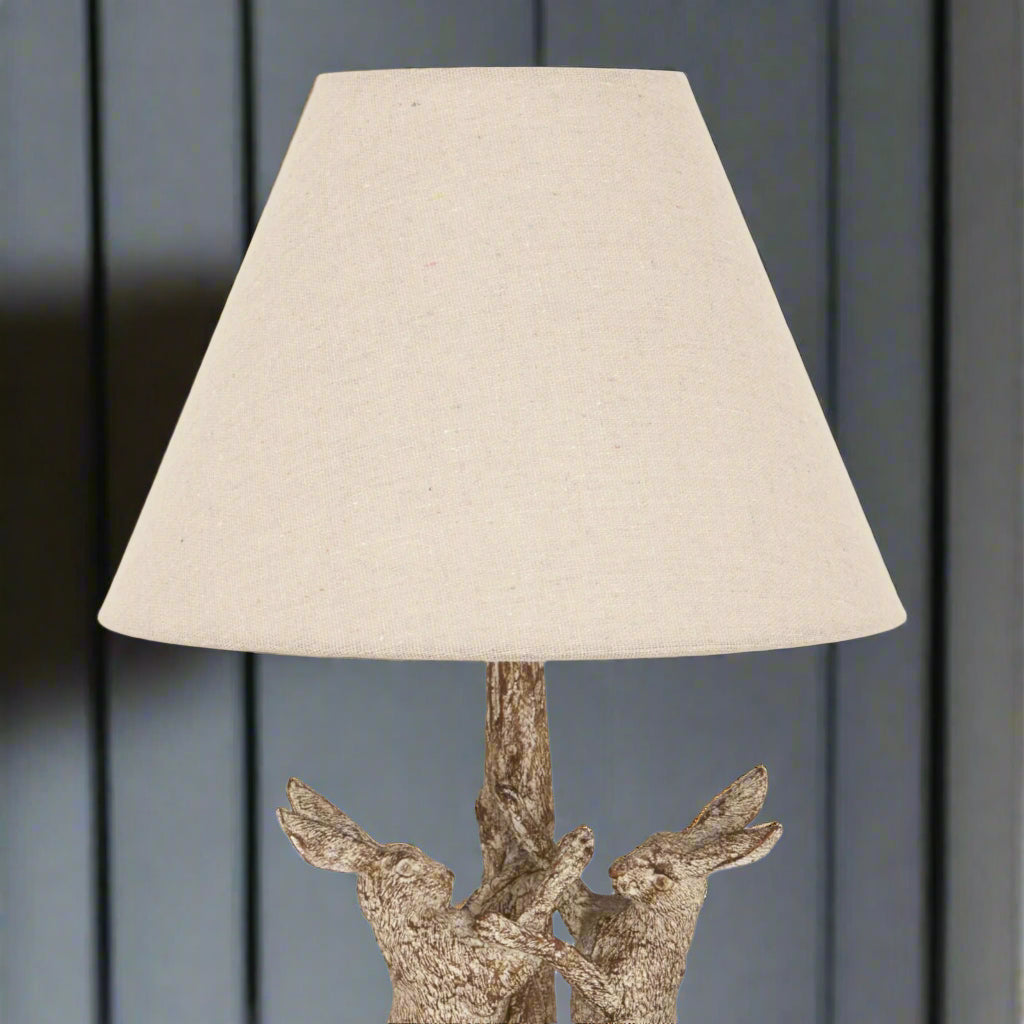 Close-up of the lamp’s linen shade, highlighting the fabric texture and soft natural tone.