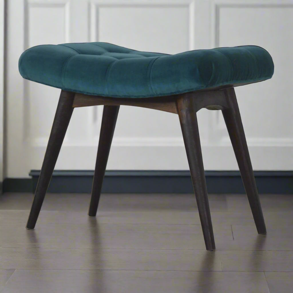 Angled view of the teal velvet curve stool from the left side, showcasing the stool and all four of its Nordic style legs.