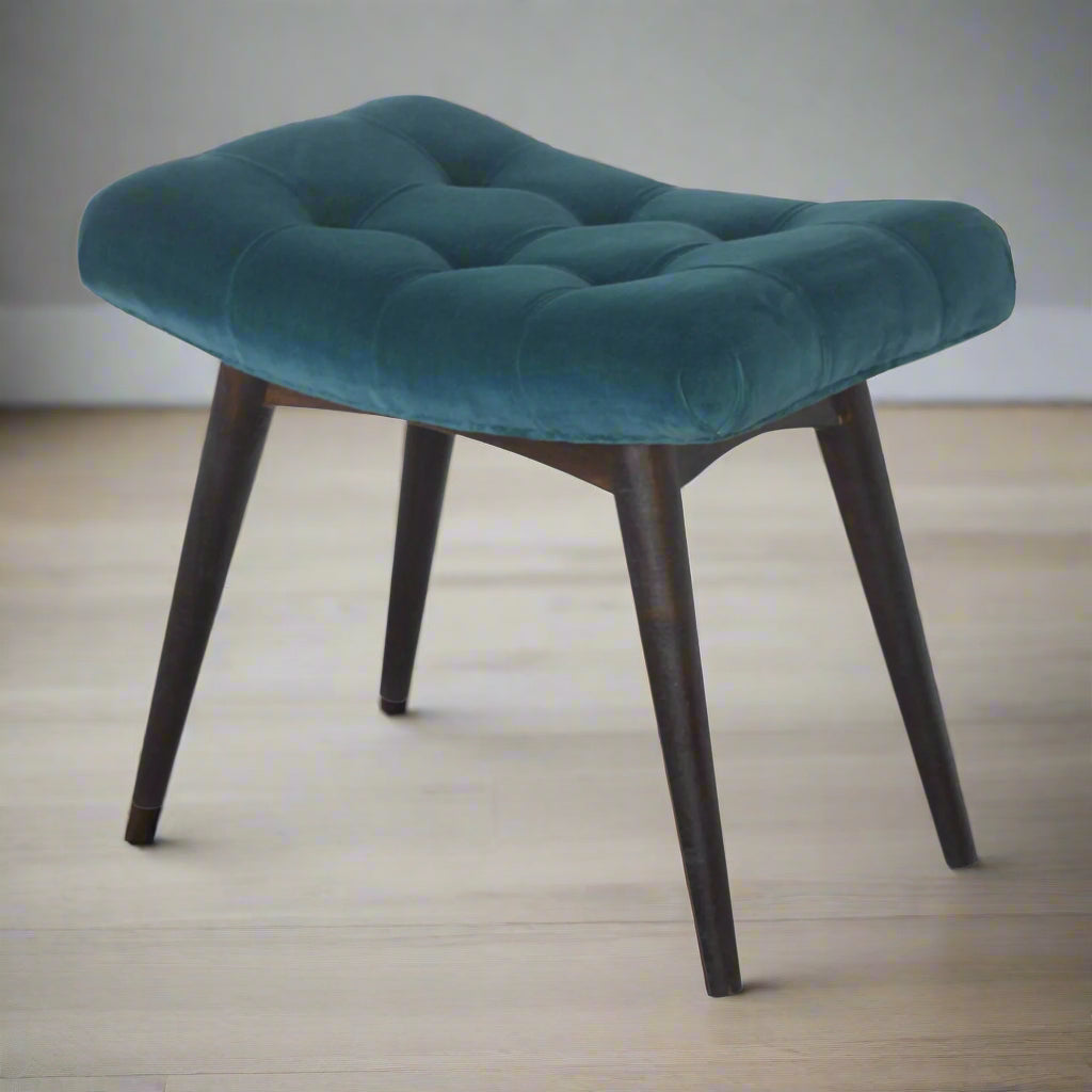 Elevated left side angled view of the teal velvet curve stool, presenting the entire stool from a dynamic perspective.