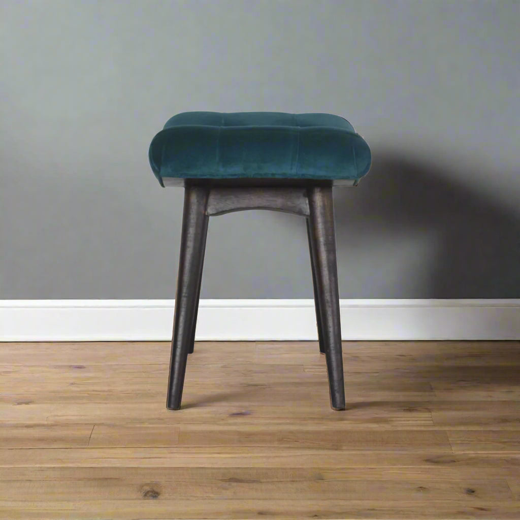Full side view of the teal velvet curve stool, displaying its elegant curved profile and sturdy construction.
