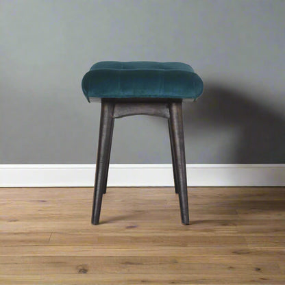 Full side view of the teal velvet curve stool, displaying its elegant curved profile and sturdy construction.