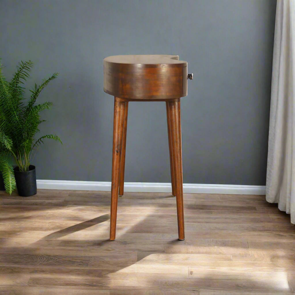 Side view of the Wave Desk, positioned with an ornamental flower, demonstrating its slim profile and how it complements decor.