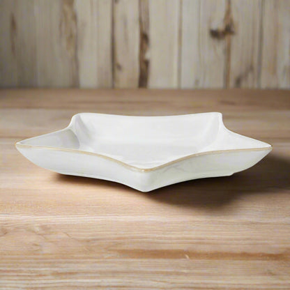 Elevated front view of the 19cm white ceramic star dish on a wooden surface, with its shadow cast on the left side.