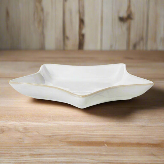 Elevated front view of the 19cm white ceramic star dish on a wooden surface, with its shadow cast on the left side.