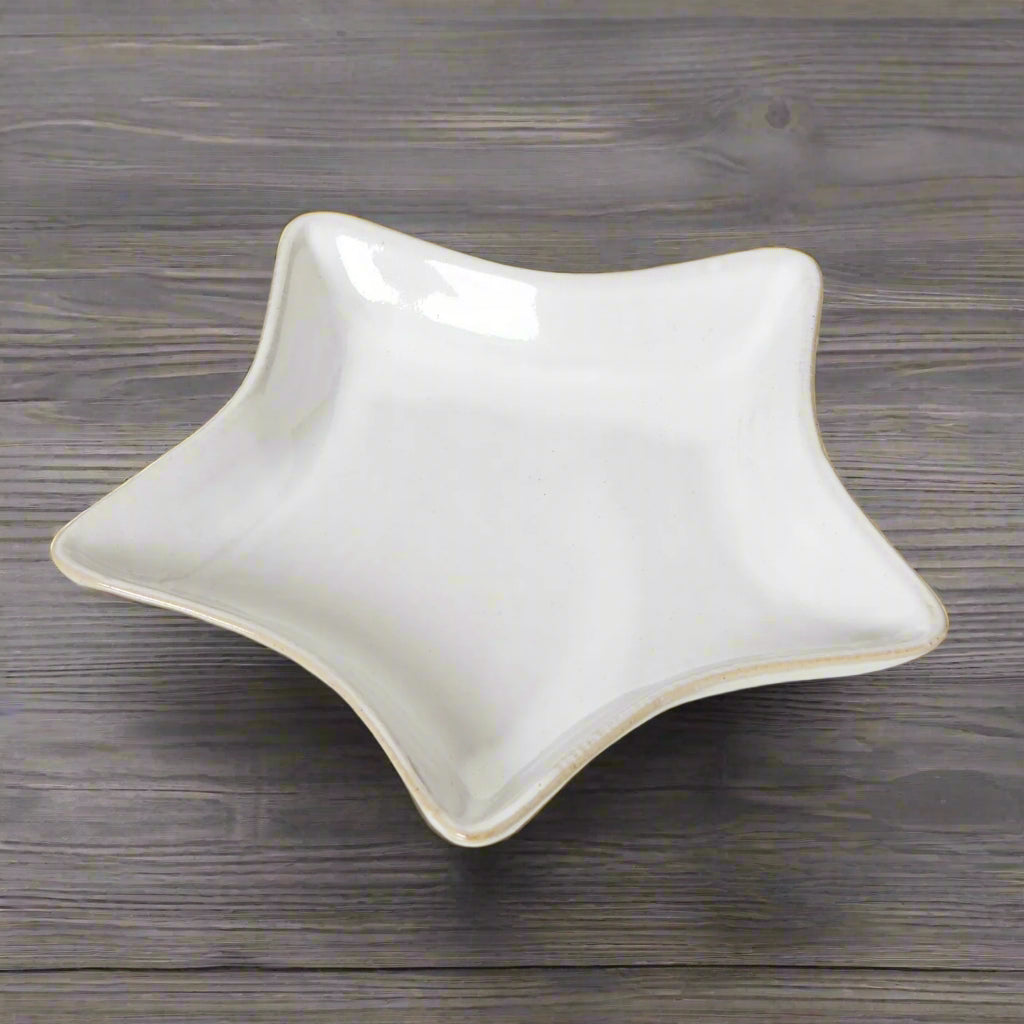 Top-down view of the 19cm white ceramic star dish on a wooden surface, highlighting its graceful contours and crisp lines.
