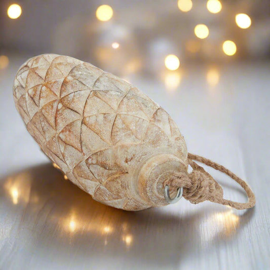 Close up view of a large wooden pinecone showcasing the intricate pine cone detailing and durable twine rope for hanging. 