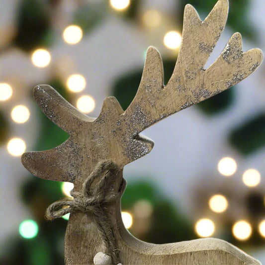 Close up of head of a wooden festive reindeer ornament with glittery antlers