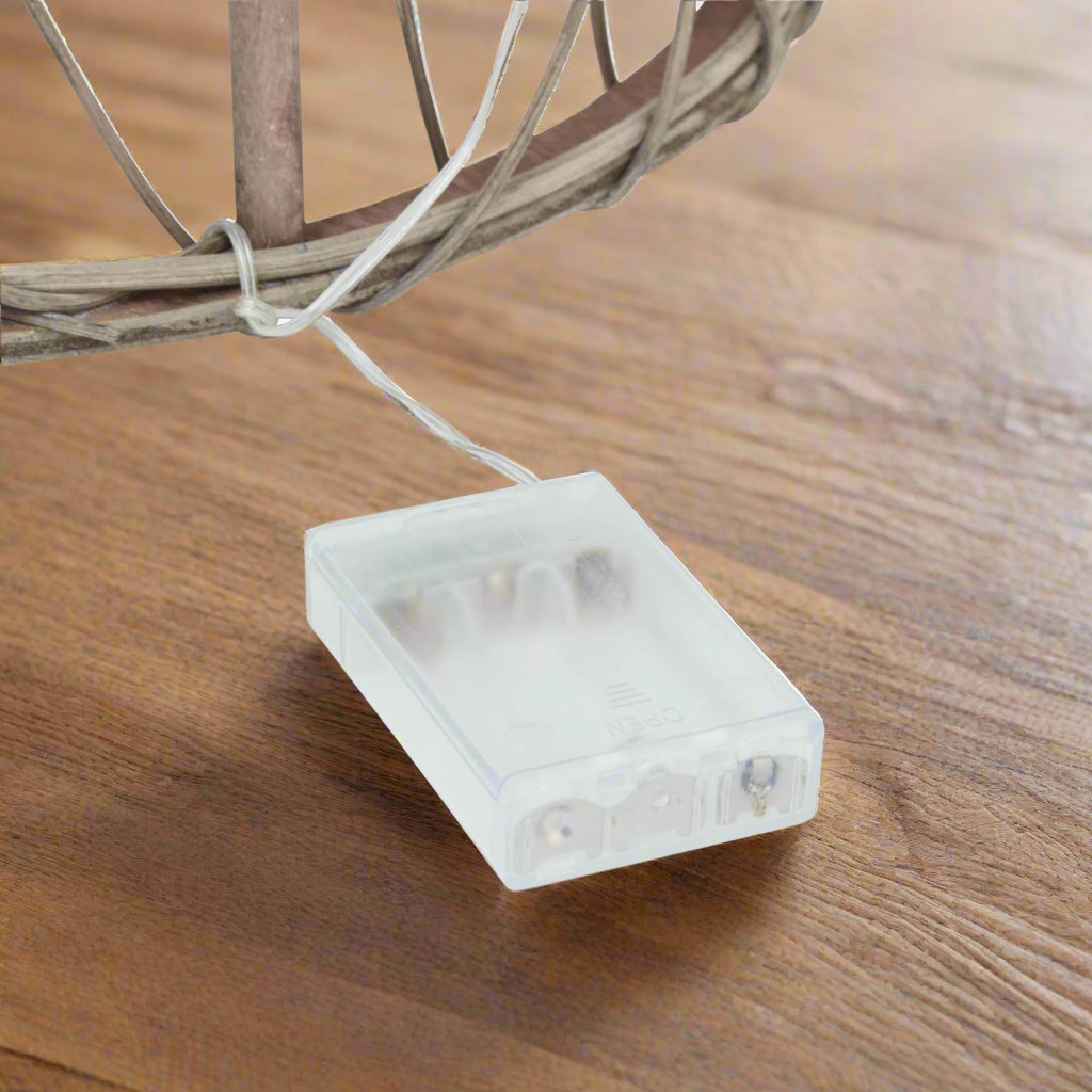 Close-up of the white battery pack for the LED lights on a large wicker Christmas tree, it is where you power the festive glow.