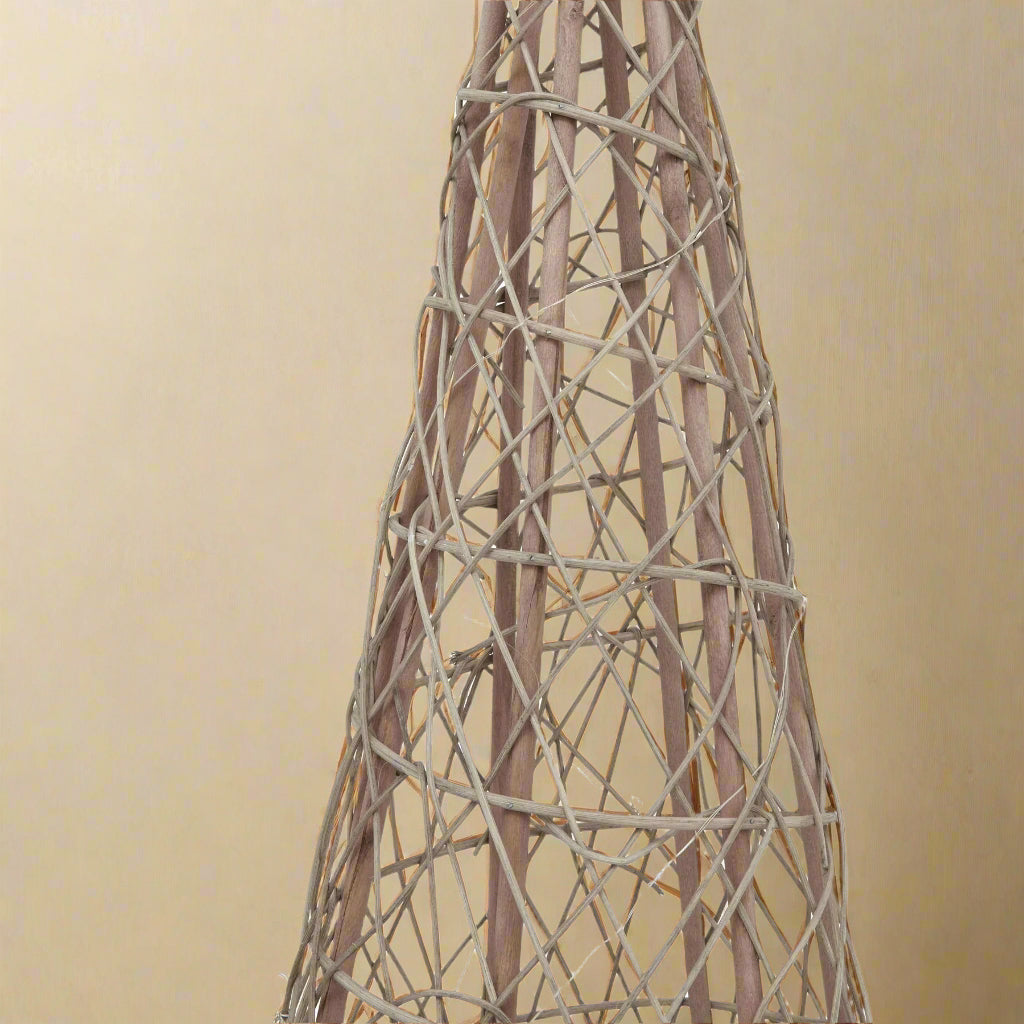 Detailed view of the natural woven wicker texture on a large LED Christmas tree, highlighting its rustic appeal.