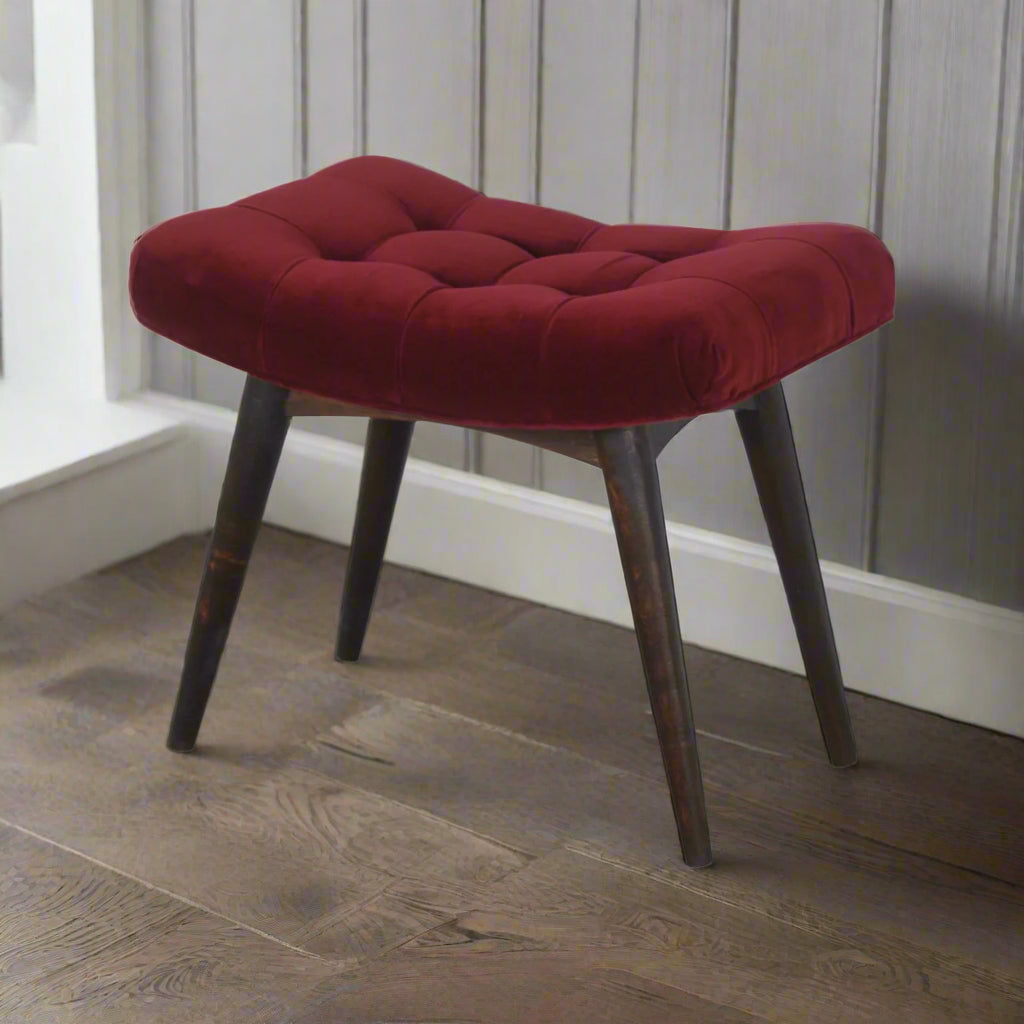 Elevated angled view of the Wine Red Velvet Curve Stool, highlighting the rich wine red cotton velvet upholstery and solid mango wood legs.