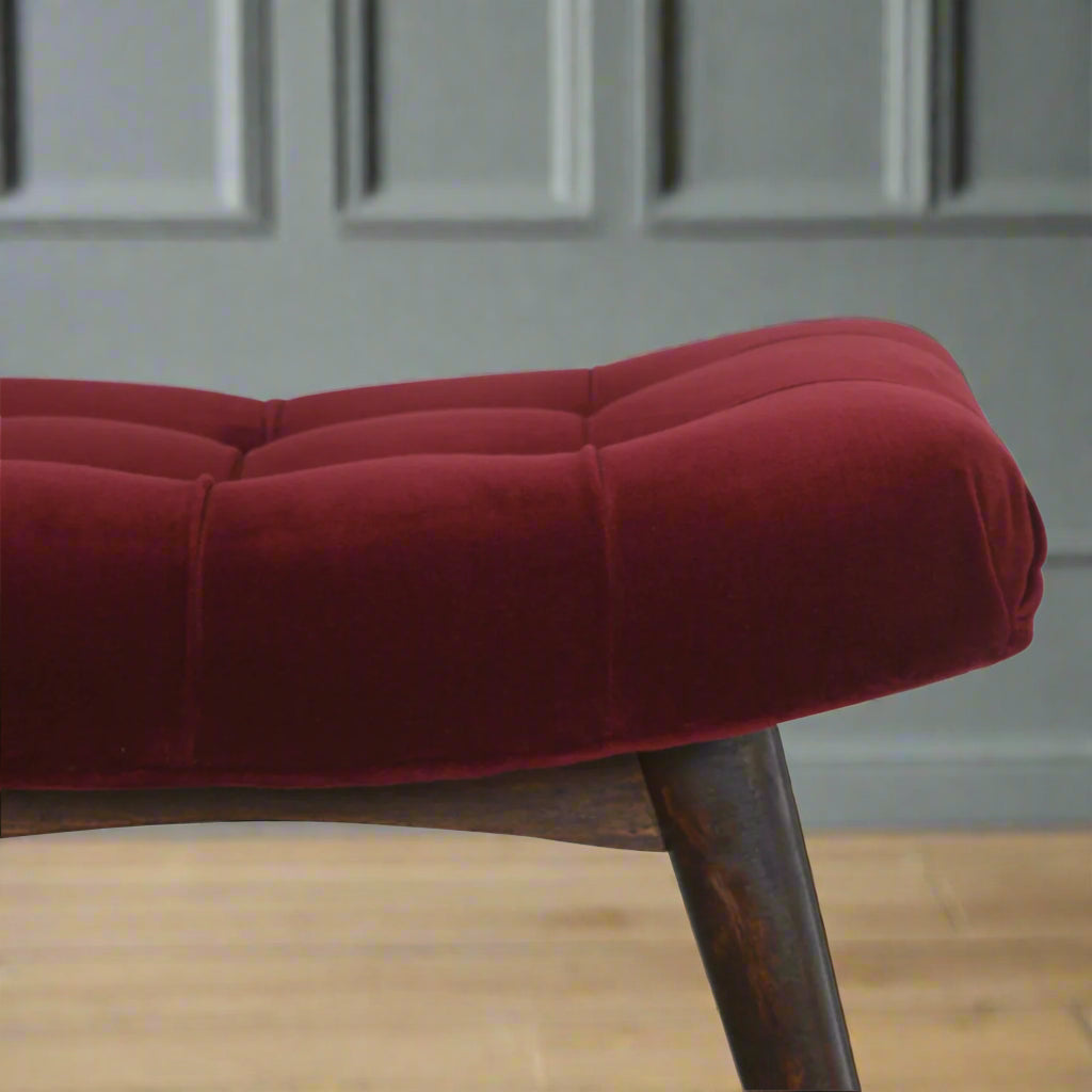 Detailed focus on the curved edge of the wine red cotton velvet upholstered seat of the Curve Stool.