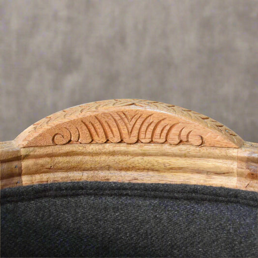 Close-up view of the hand-carved natural wood detailing on the backrest, showcasing craftsmanship and elegant finish.