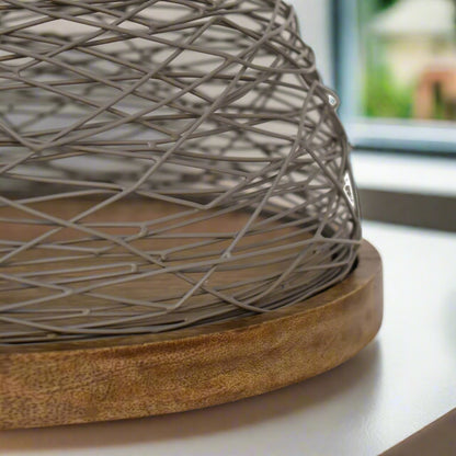 Detailed shot of the Blue Bird Nest Cake Stand’s smooth wooden base and blue netted top craftsmanship