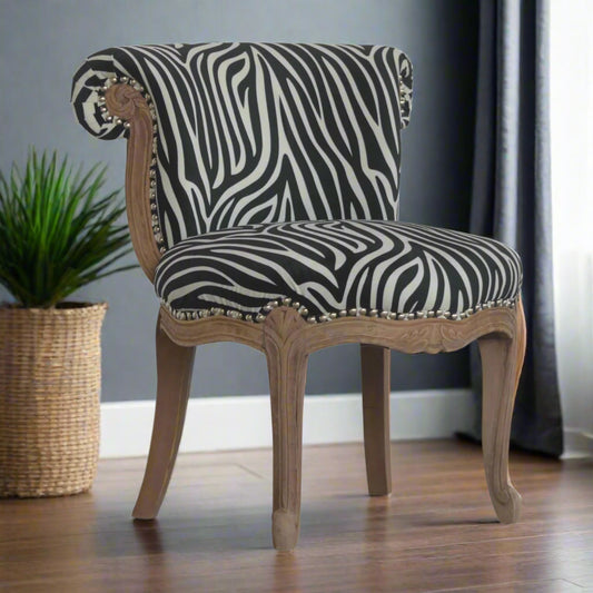 Angled shot showing the black and white velvet zebra fabric and elegant carved legs